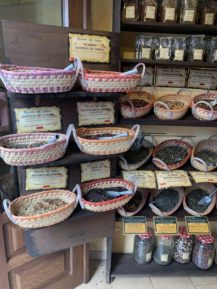 Étal de marché avec des paniers d'épices et d'herbes aromatiques.