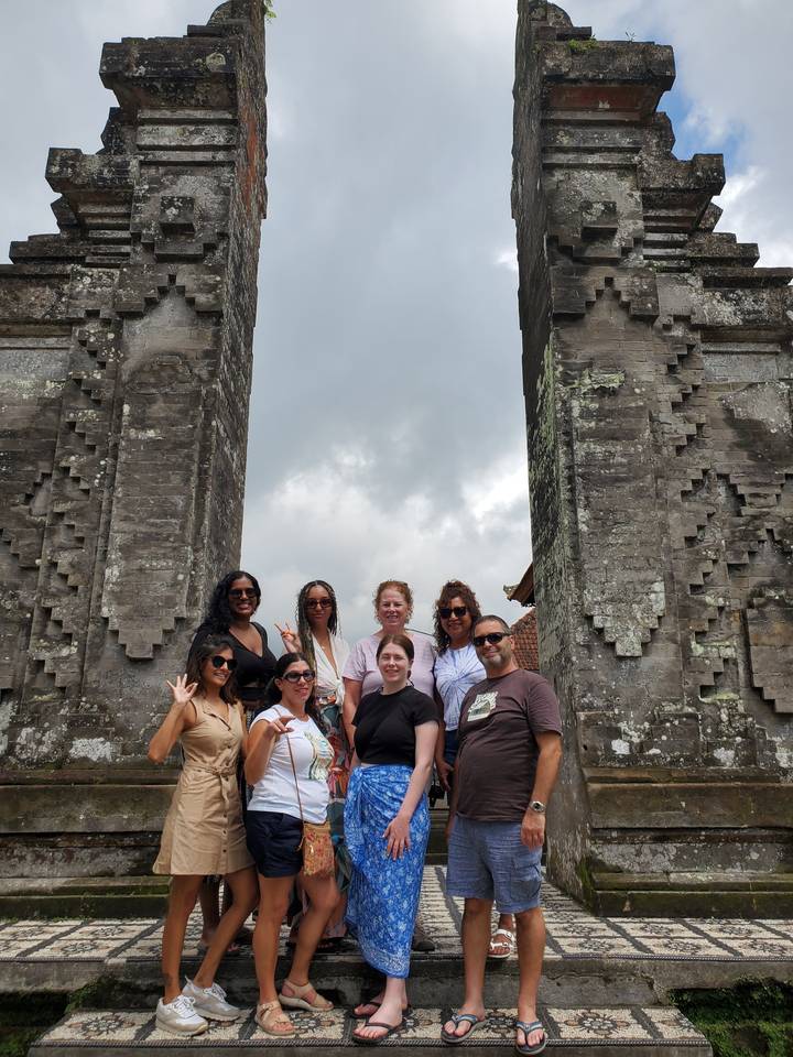 Un groupe de personnes posant sous un portail de pierre.