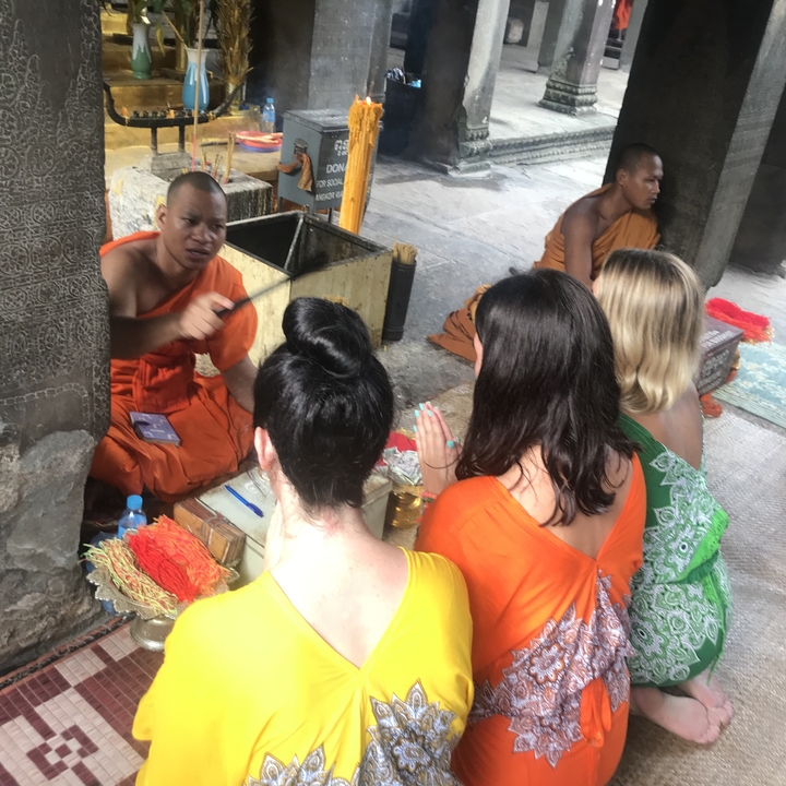 Moines et touristes dans un cadre traditionnel.