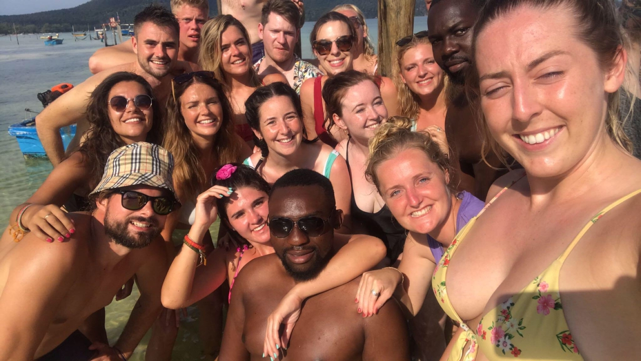 Grand groupe de personnes prenant un selfie dans l'eau.