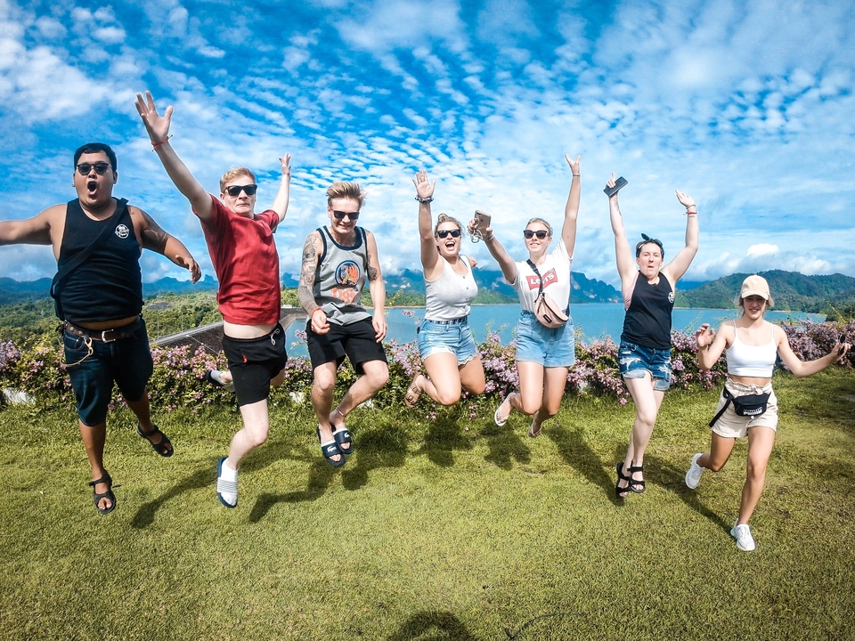 Group of people jumping with joy in a scenic landscape.
