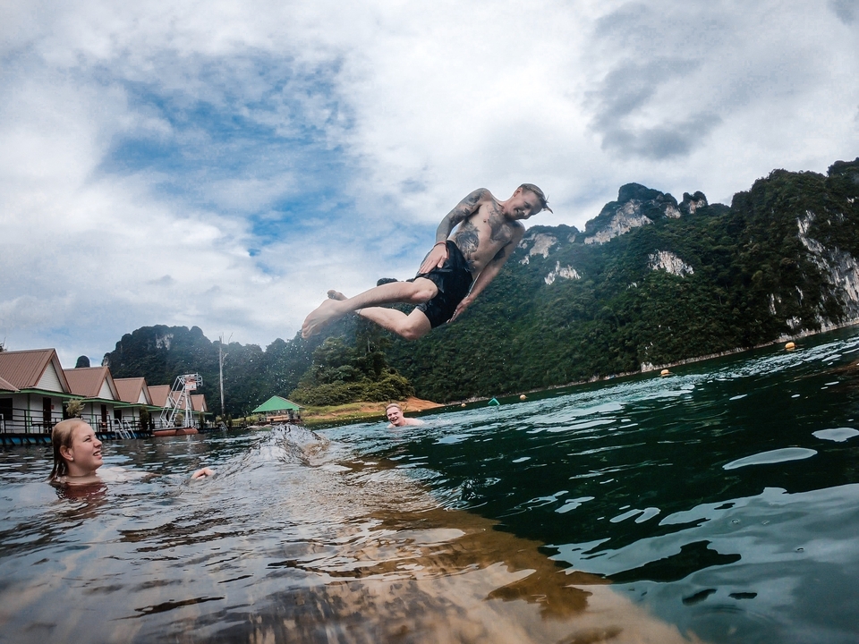Person performing an acrobatic jump into water.