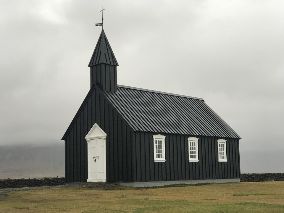 Église noire contre un ciel nuageux.