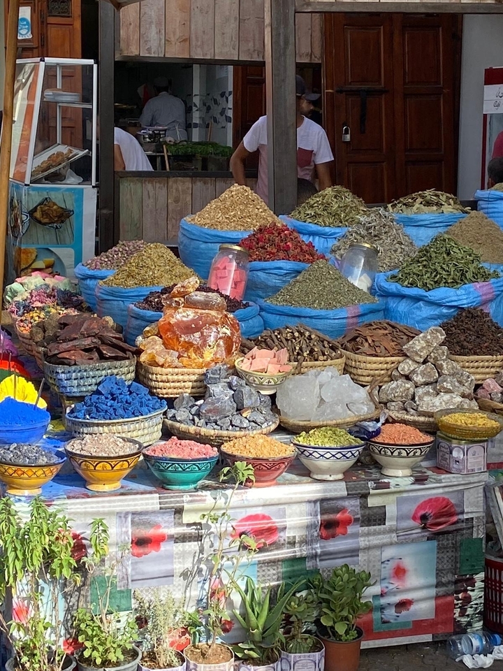 Variété d'épices colorées et de pierres exposées dans un marché.