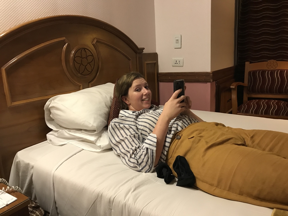Personne se détendant sur un lit en regardant son téléphone.