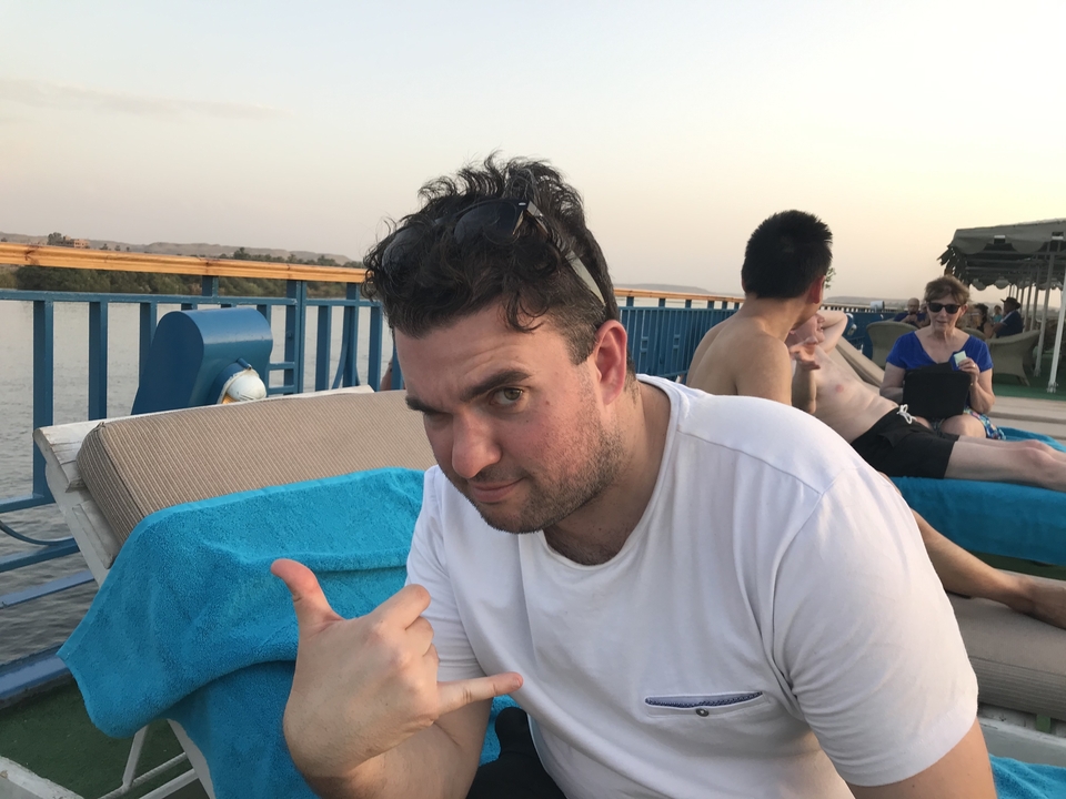 Personne se détendant sur une chaise longue à bord d'une croisière avec vue sur la rivière.