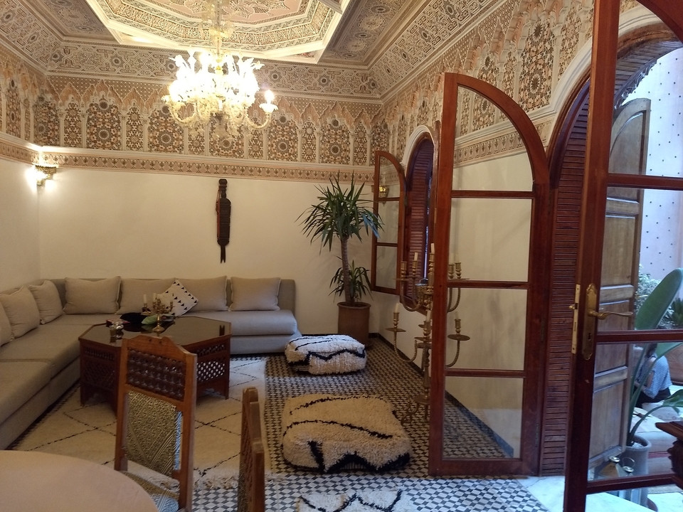 Ornate Moroccan interior with a seating area and decorative walls.