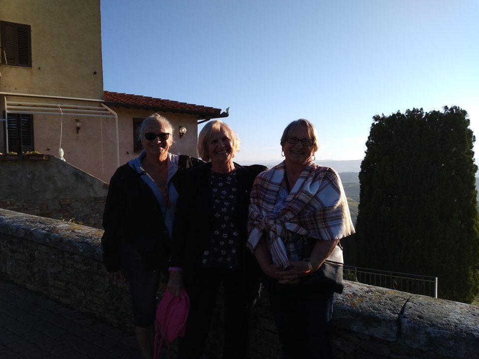Trois femmes posant en extérieur avec une vue panoramique.