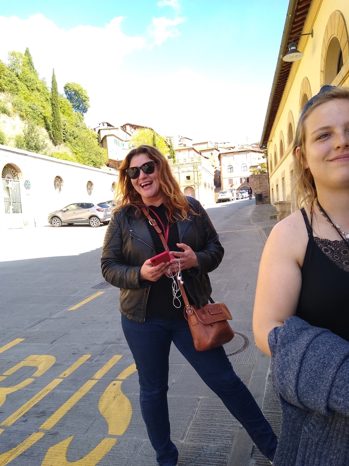 Femme heureuse dans une rue bordée de bâtiments.