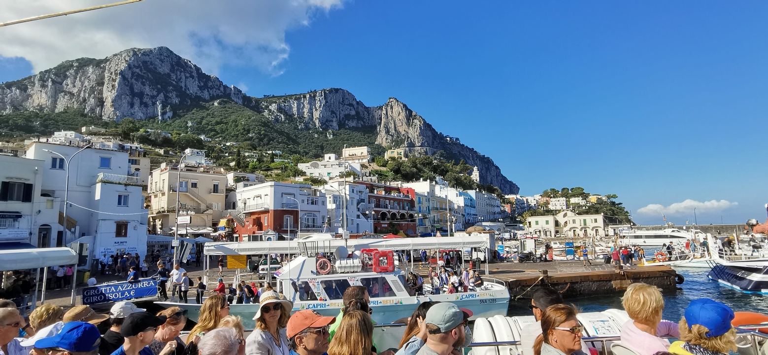 Scène animée du front de mer avec des bâtiments colorés et des bateaux à Capri.
