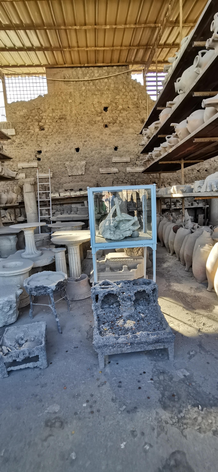 Artefacts et sculptures dans une vitrine d'exposition sur un site archéologique.