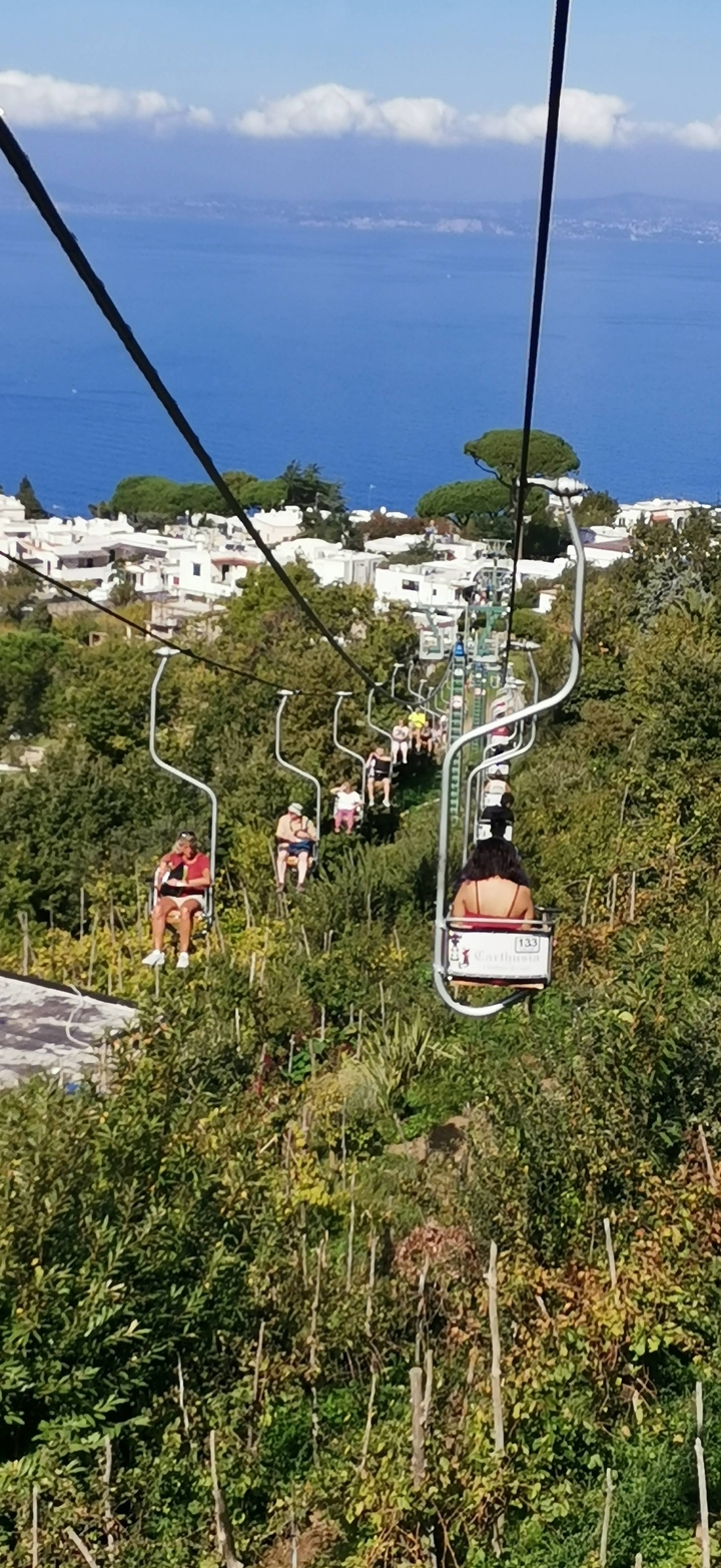 Des gens dans un télésiège qui remontent une colline.