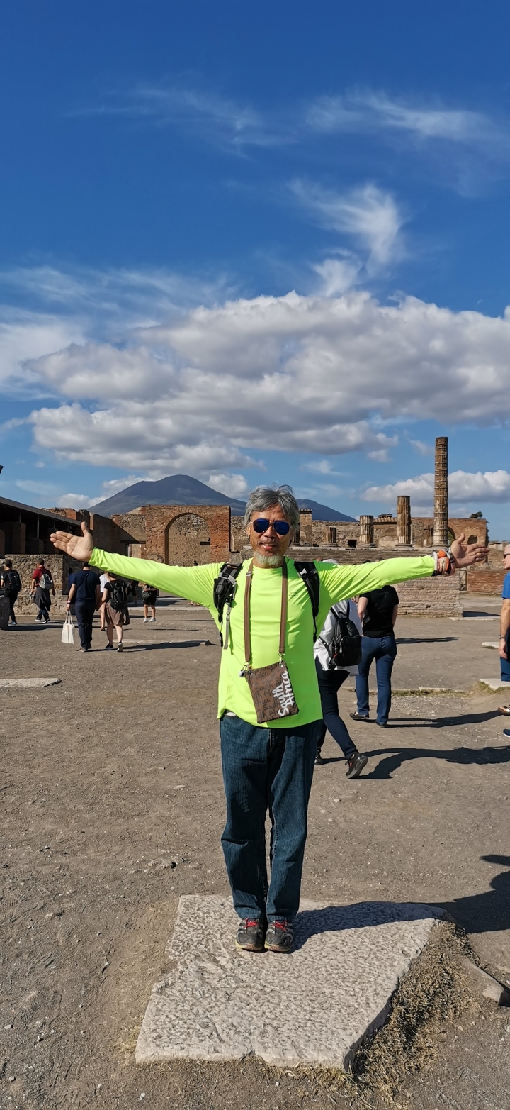 Personne posant les bras grands ouverts devant les ruines de Pompéi.