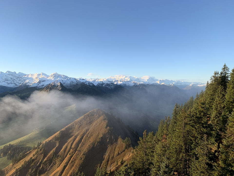 Paysage de montagne avec des sommets et du brouillard épars.