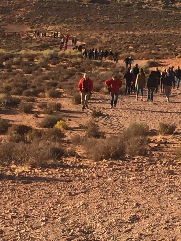 Groupe de personnes marchant dans un paysage désertique.