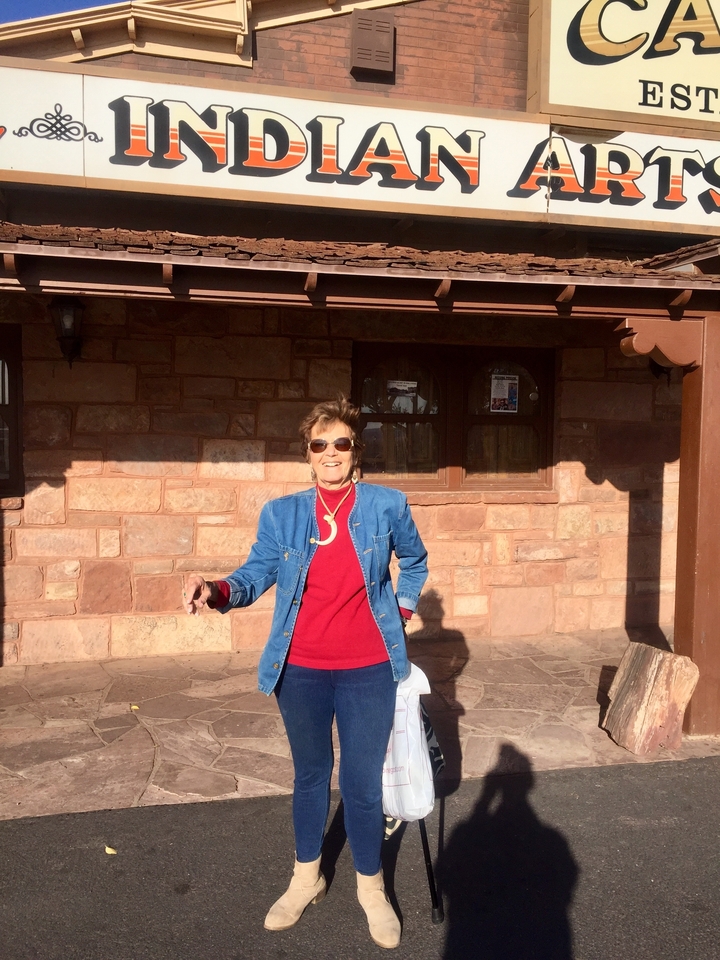 Personne posant devant un bâtiment en pierre.