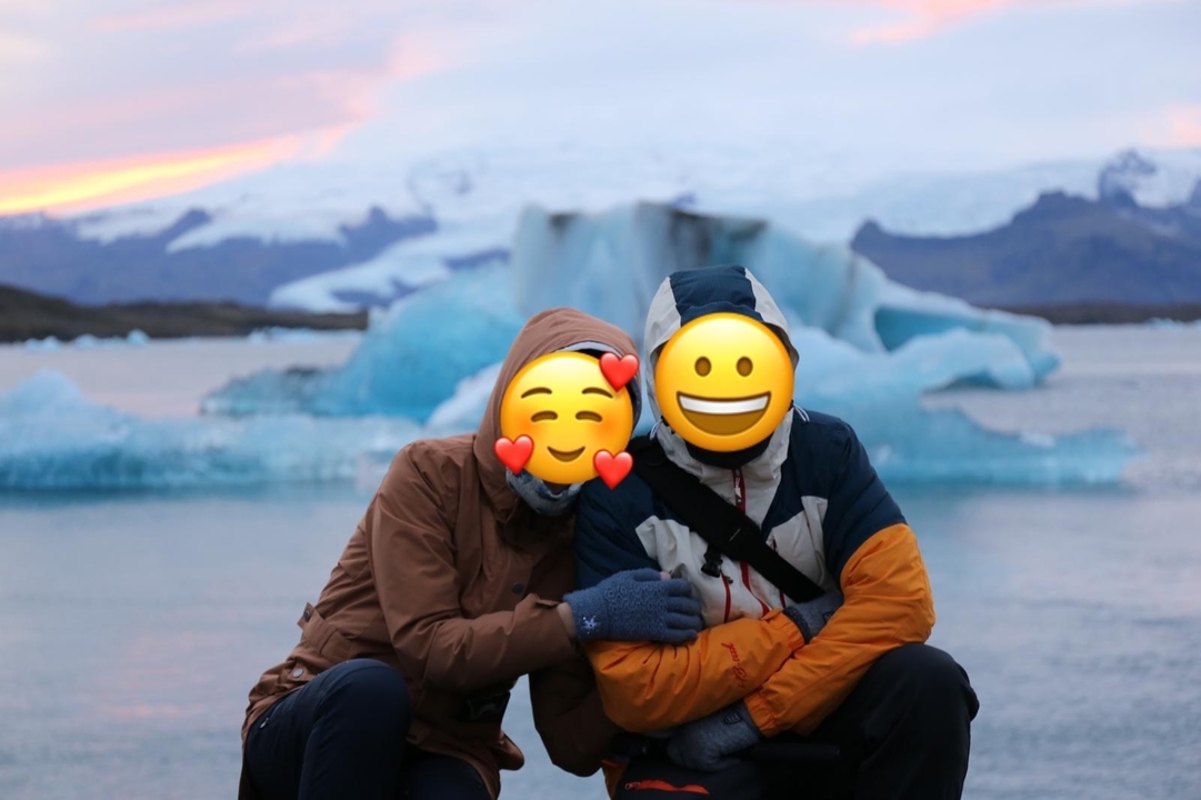Couple posant devant un lagon glaciaire.