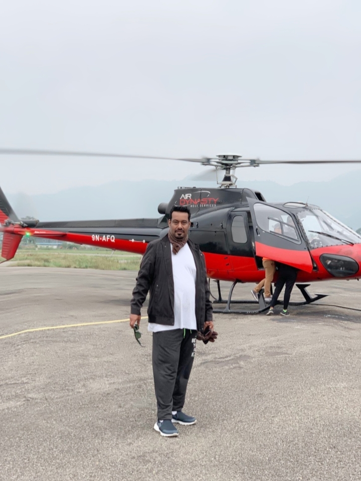 Personne debout devant un hélicoptère.