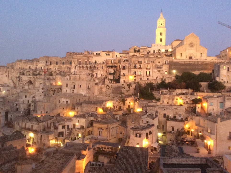 Vue nocturne d'une vieille ville avec des lumières brillantes.
