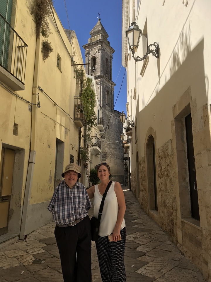 Deux personnes posant dans une rue historique étroite.