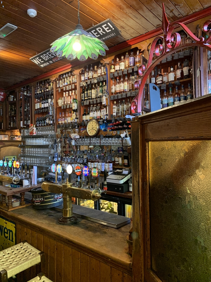 Intérieur d'un pub avec diverses bouteilles exposées.