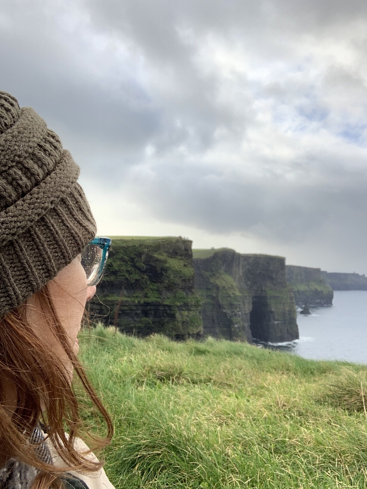 Femme regardant les falaises de Moher.
