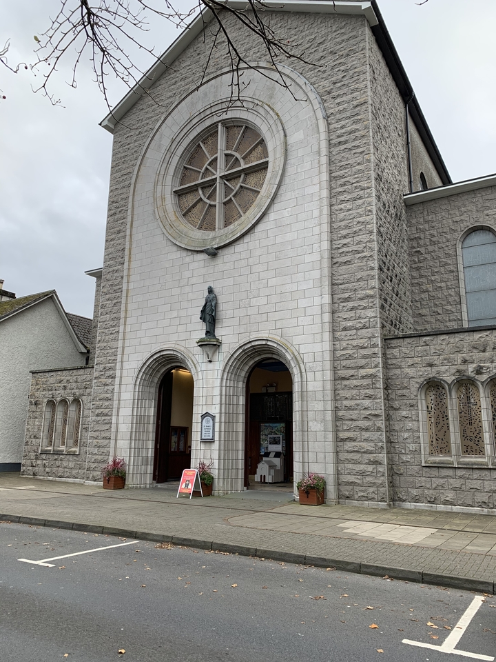 Une église en pierre avec une grande fenêtre circulaire.