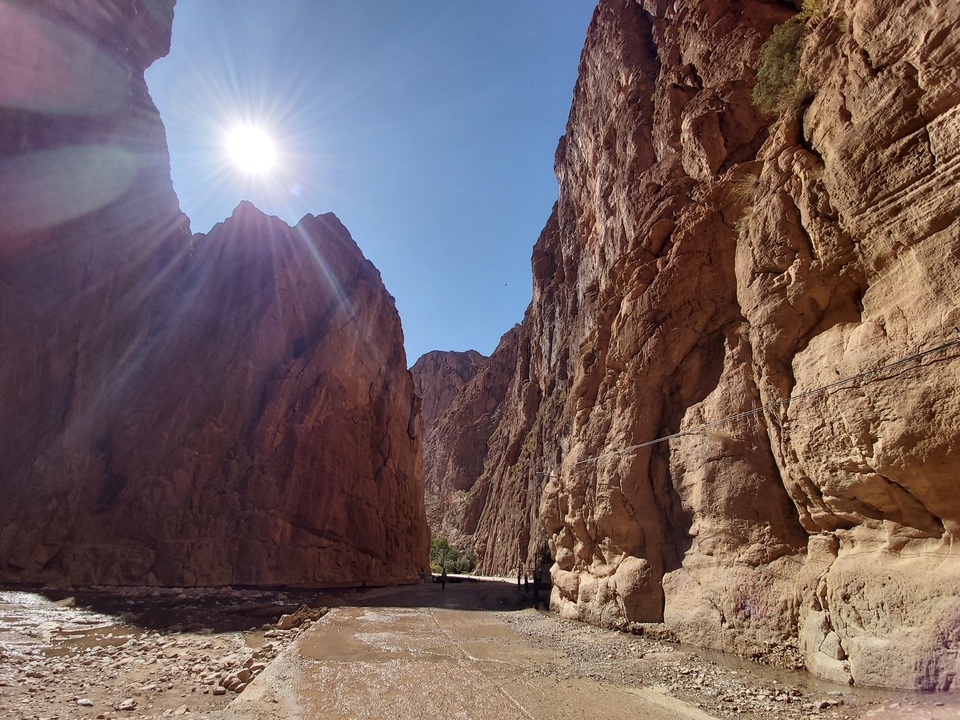 Here's the French translation:
Les rayons du soleil filtrent entre les hautes parois du canyon.