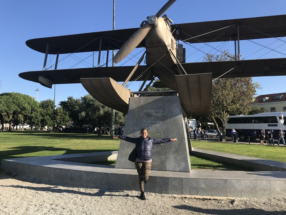 Femme debout sous un monument d'avion historique.