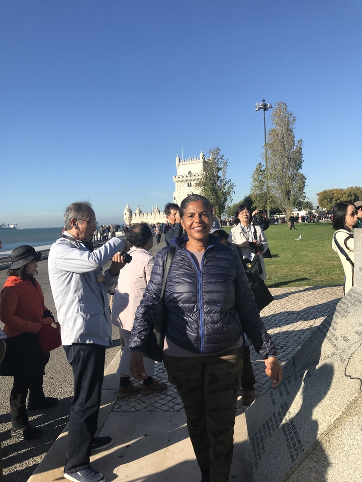 Des gens visitant la tour de Belém au bord de la rivière.
