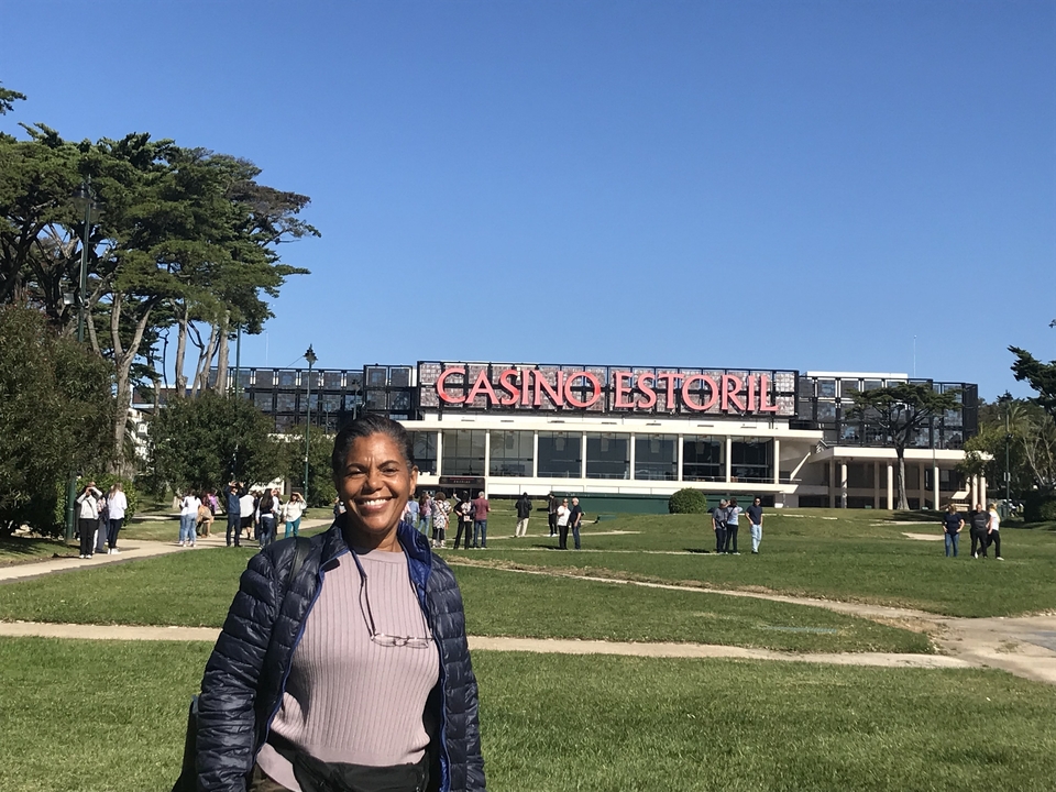 Femme posant près de l'enseigne du Casino Estoril.