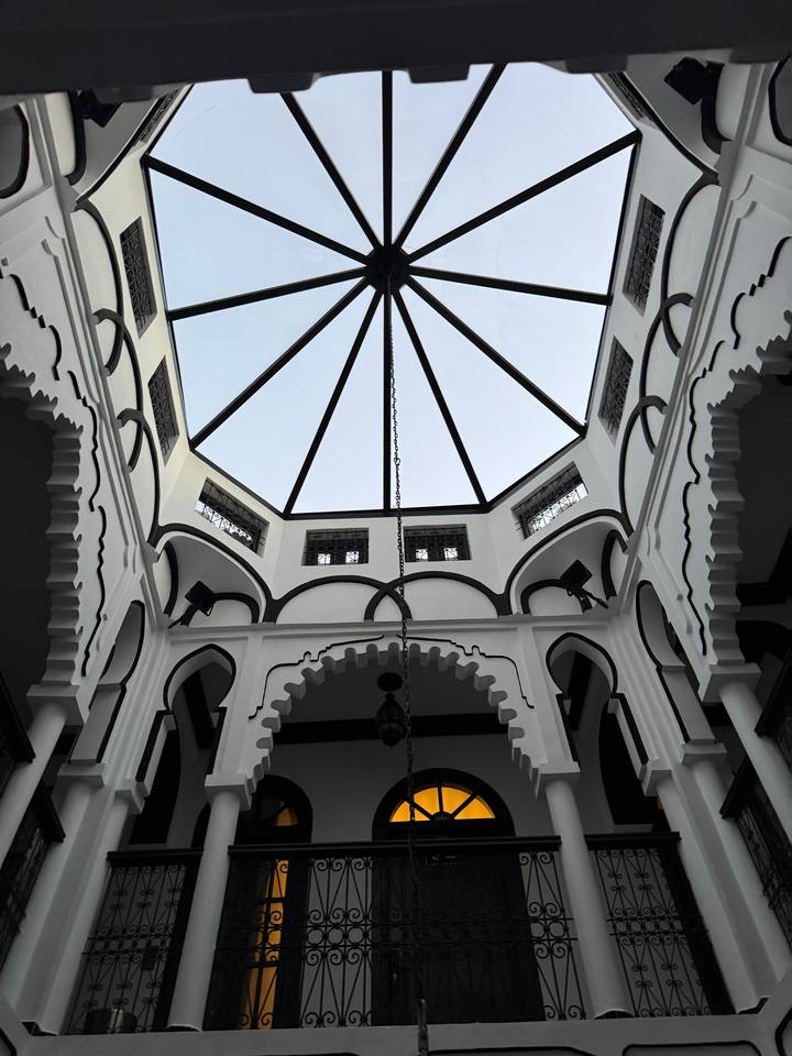 Un plafond décoratif avec des motifs géométriques et un lustre central.