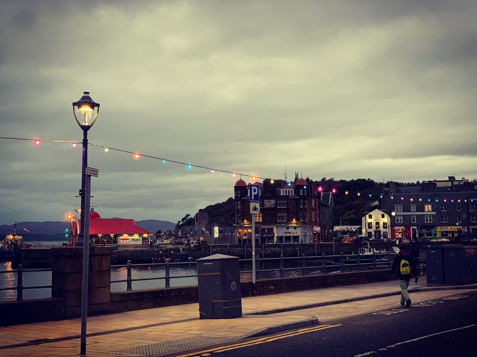 Promenade du front de mer avec des lumières colorées et des bâtiments.