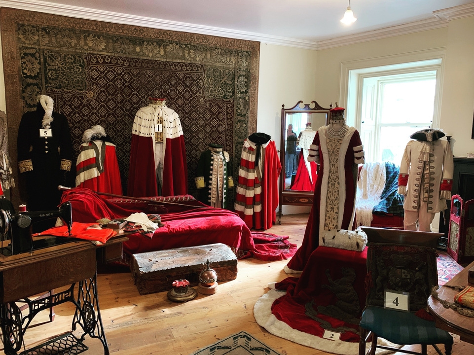 Salle remplie de vêtements traditionnels et de costumes exposés.