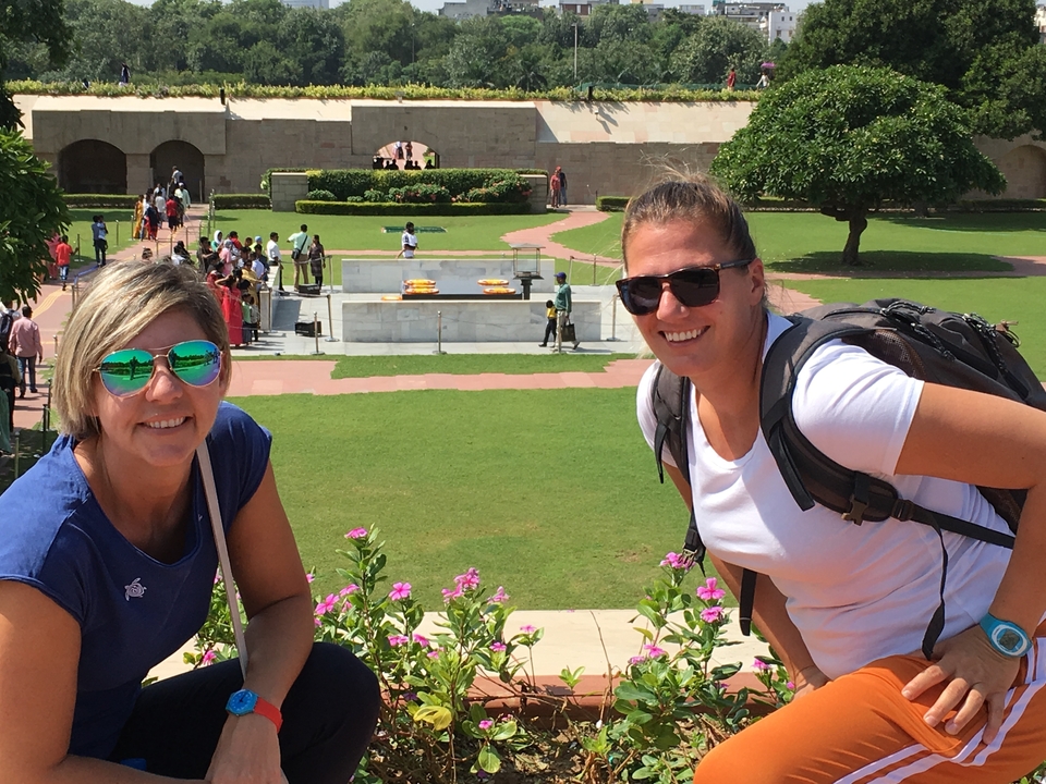 Deux personnes posant sur un site commémoratif avec d'autres personnes en arrière-plan.