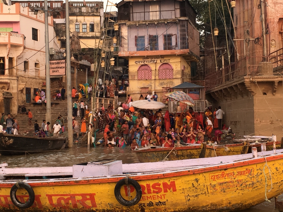 Berge de rivière bondée avec des gens et des bateaux près de bâtiments historiques.