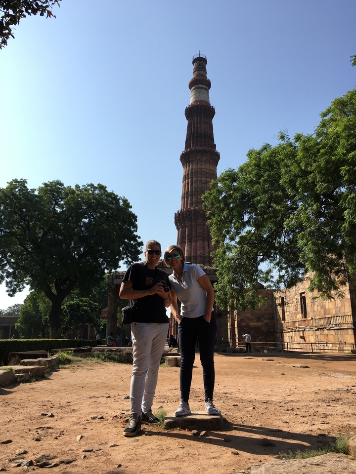 Deux personnes posant avec une tour historique en arrière-plan.