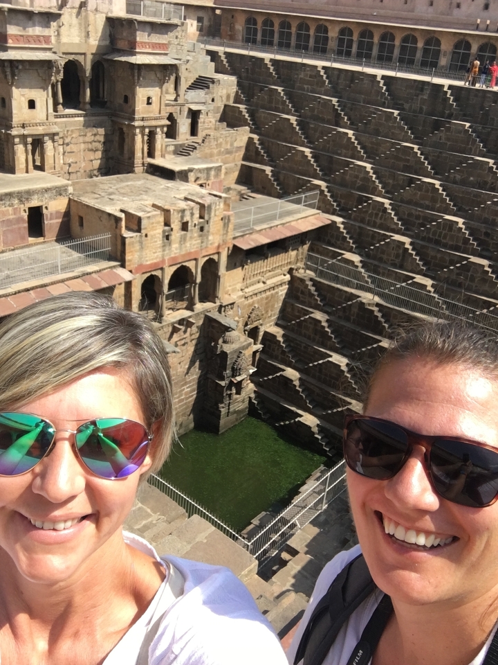 Deux personnes posant au-dessus d'un puits à degrés historique.