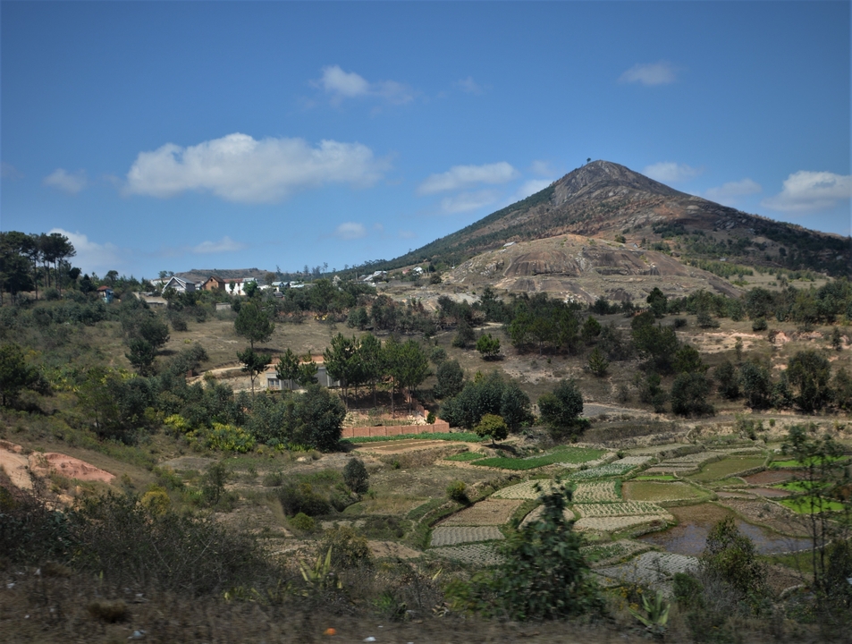 Paysage pittoresque de Madagascar avec des collines et des villages ruraux.