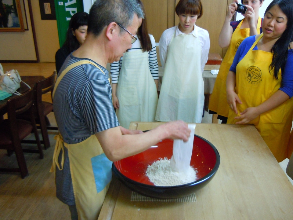 Personnes participant à un cours de cuisine, mélangeant des ingrédients dans un bol.