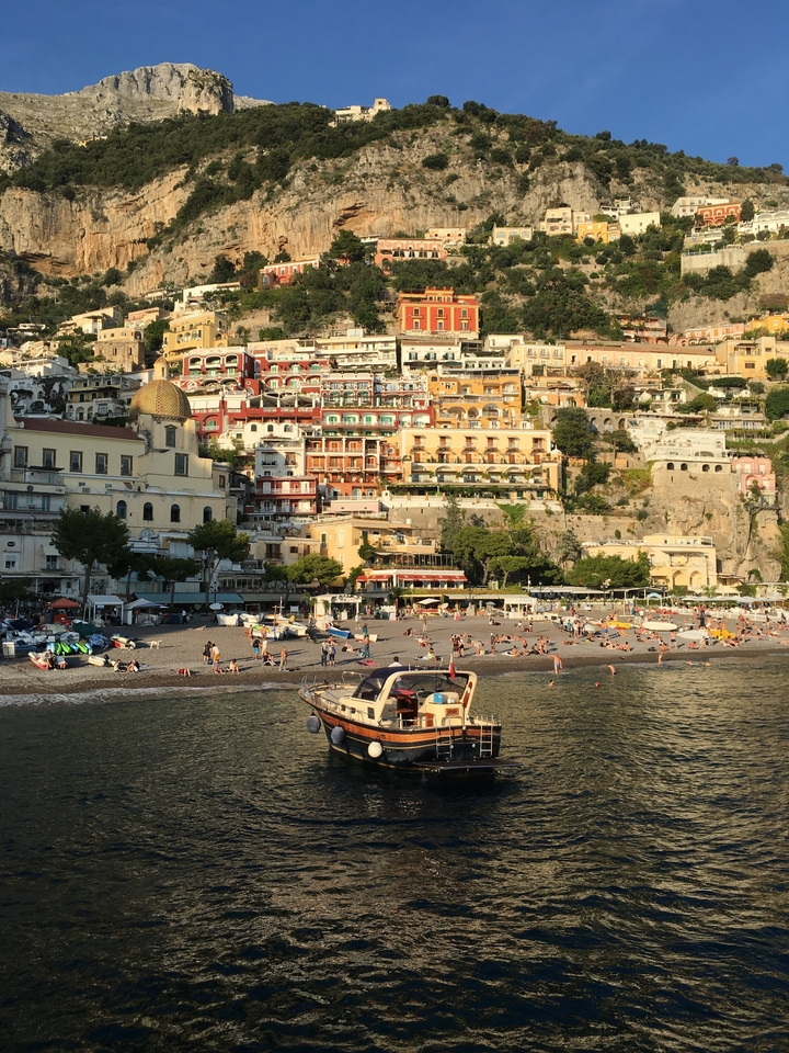 Vue de Positano avec des maisons colorées sur la colline près de la plage.