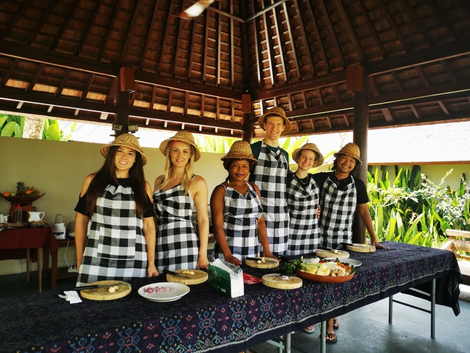 Des gens posant avec des chapeaux de paille et des tabliers avec des plats préparés.