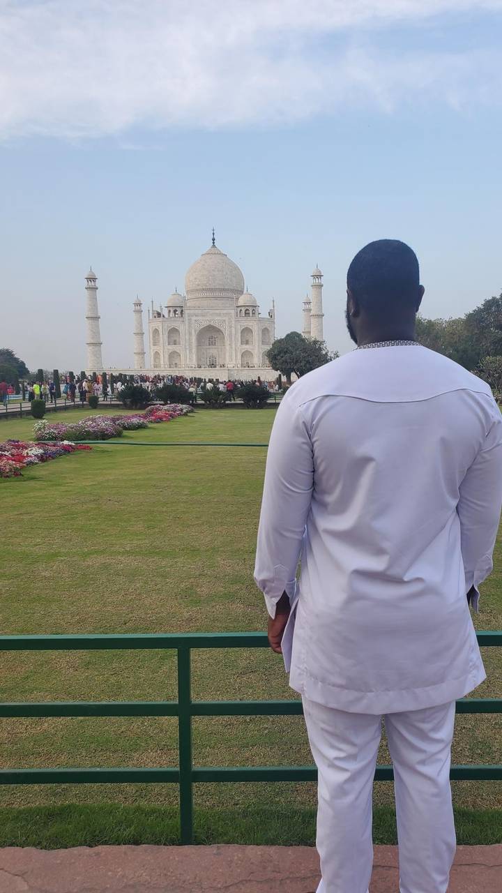 Personne en blanc se tenant devant le Taj Mahal avec des jardins.