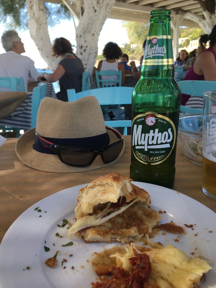 Table avec bière, chapeau, lunettes de soleil et pâtisserie.