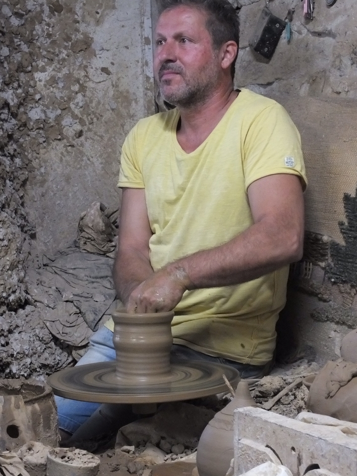 Homme façonnant de la poterie à la main à l'intérieur.