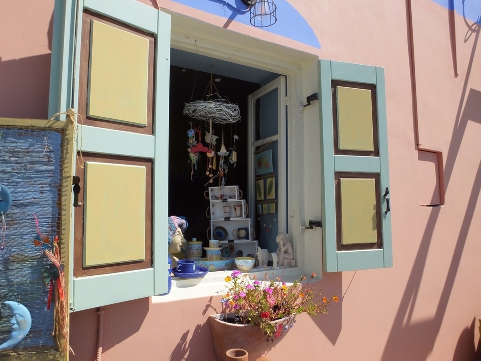 Fenêtre ouverte avec objets décoratifs et fleurs.