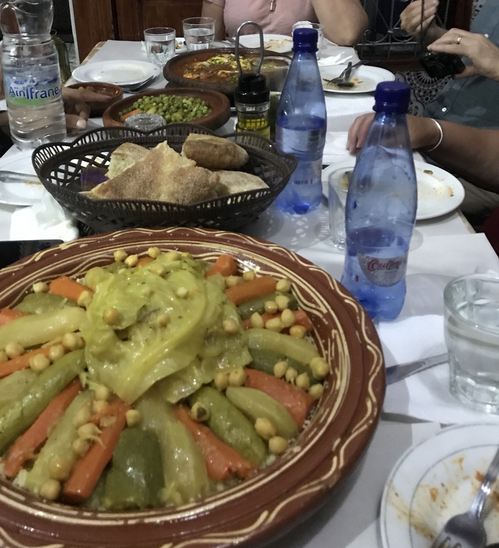 Plat de légumes marocain avec pain et eau en bouteille.