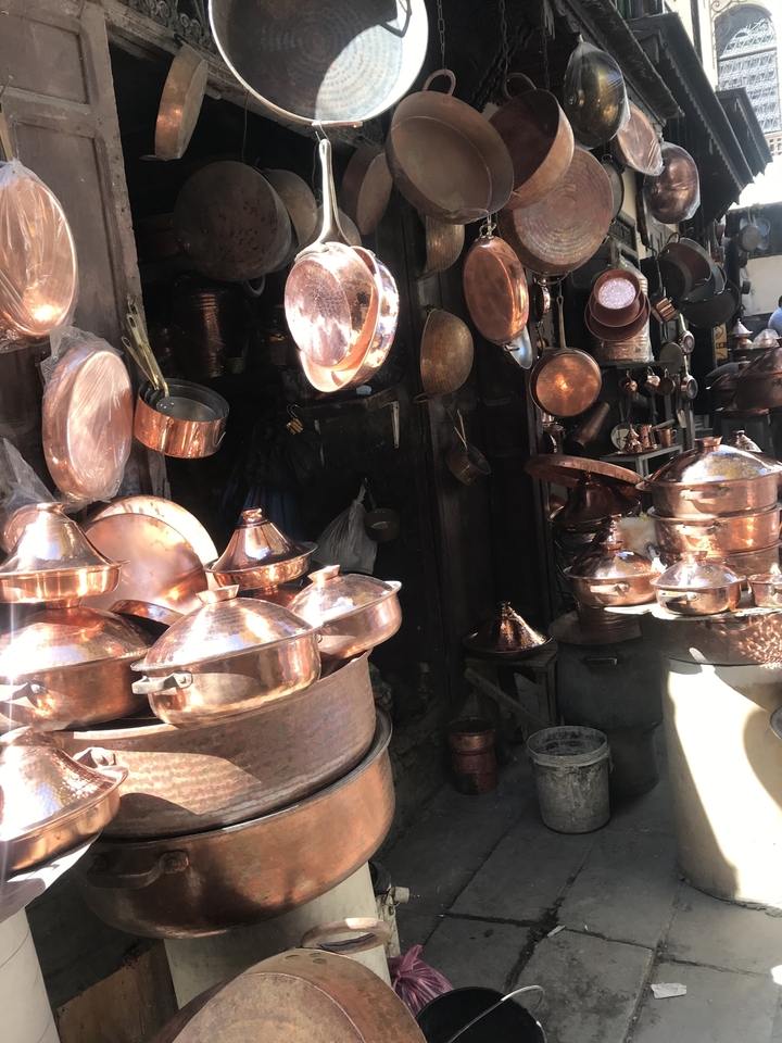 Étal de marché avec des ustensiles de cuisine en cuivre au Maroc.