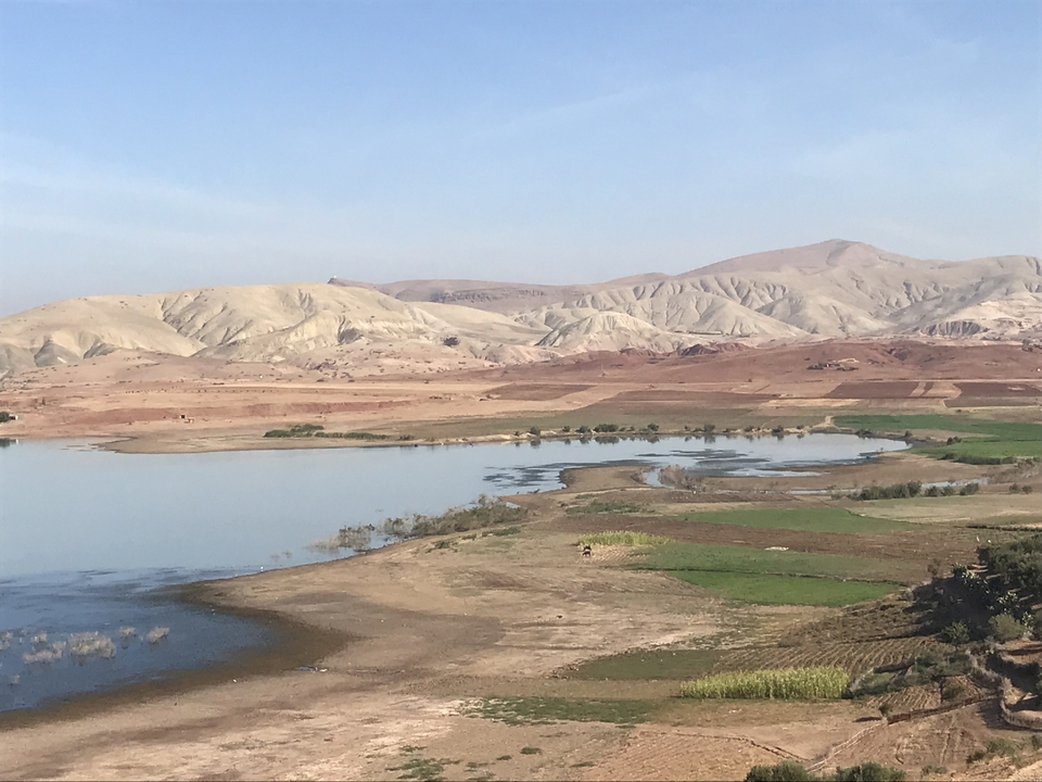 Vue panoramique d'un lac avec des collines en arrière-plan.