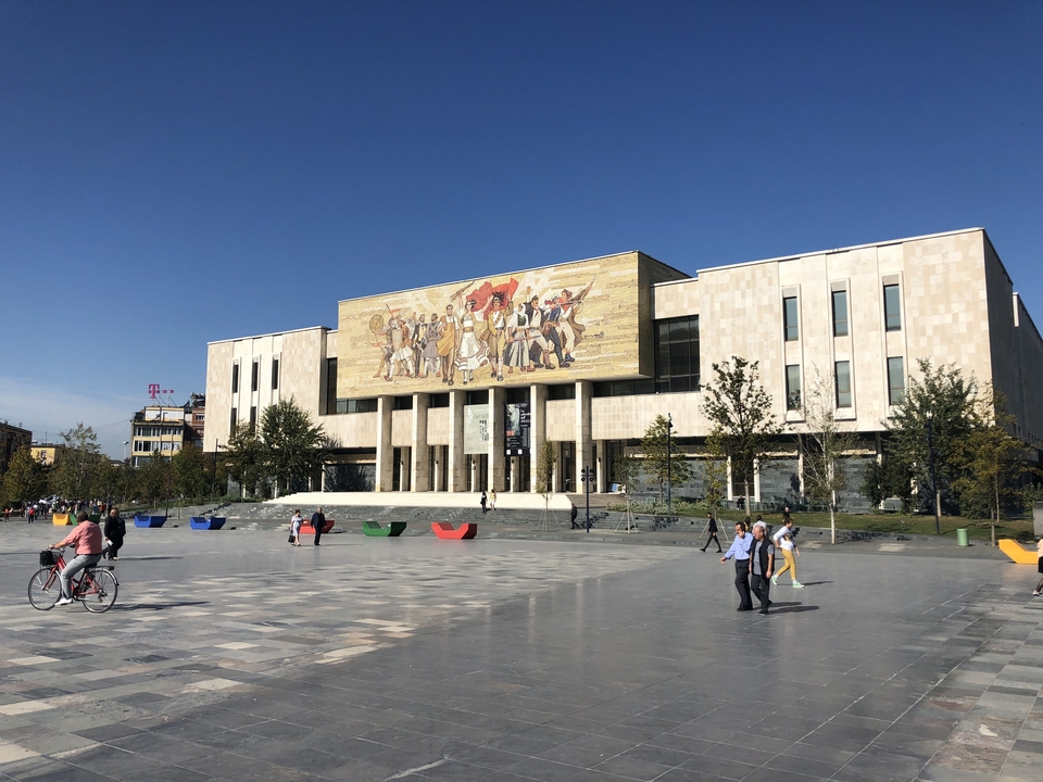 Mensen voor een groot gebouw met een muurschildering.